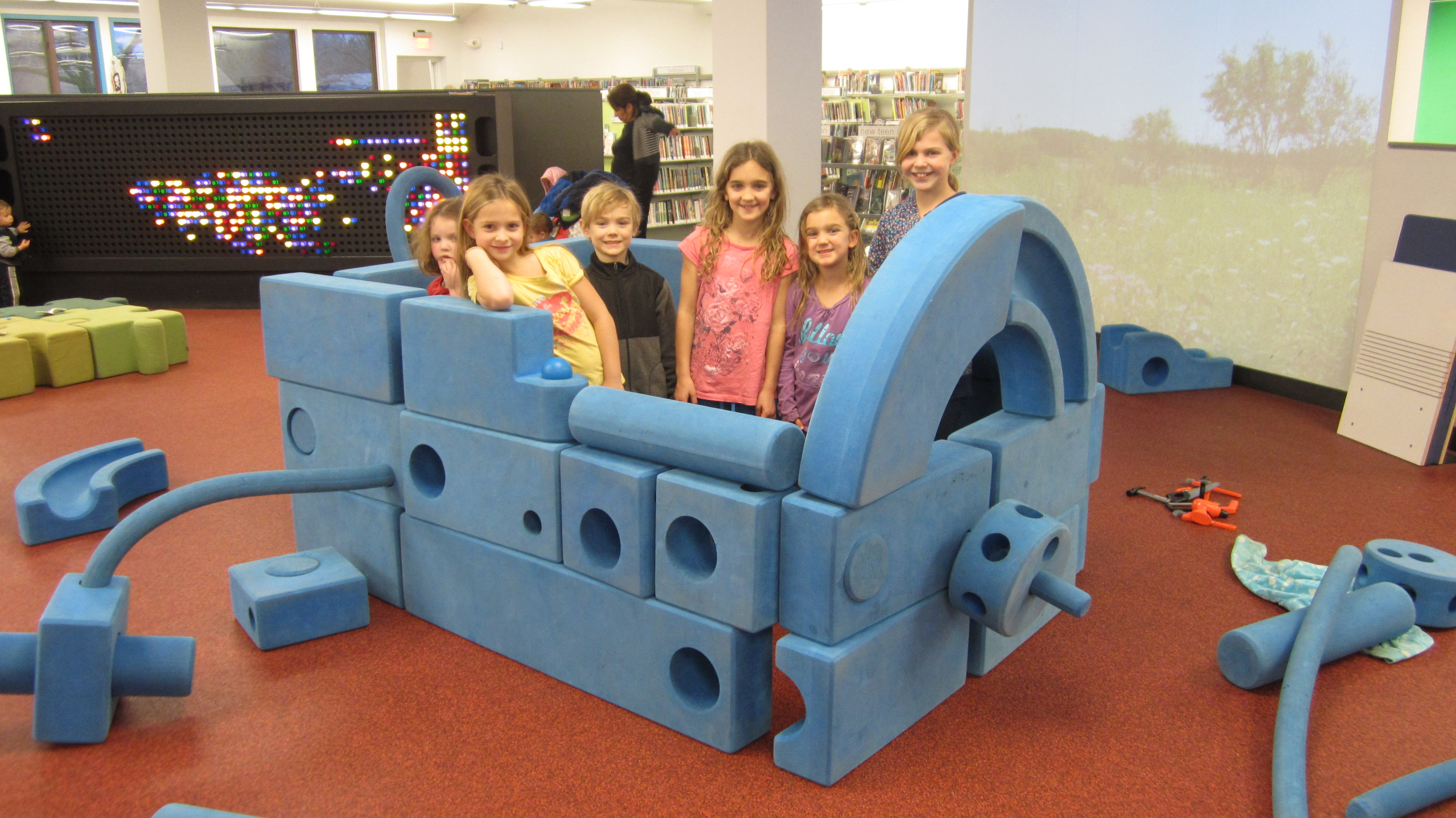 Children playing with large blue blocks in the youth services department