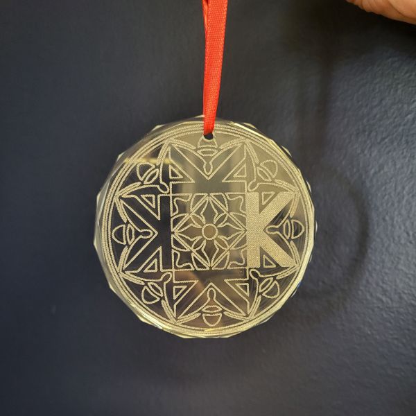 Flat glass ornament with beveled edge, etched on the laser cutter with the Kaleidoscope School of Fine Arts logo.
