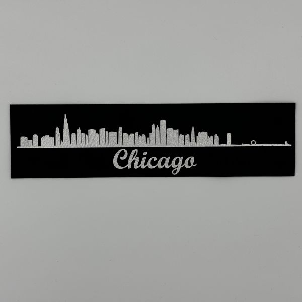 Chicago skyline etched in the the black leather-like sheet, revealing the silver layer underneath.
