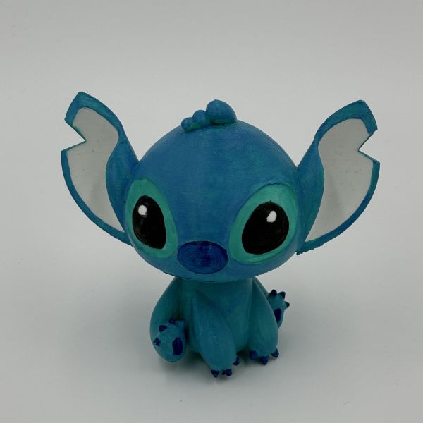 Stitch figure painted in blues and greens with acrylic paint.