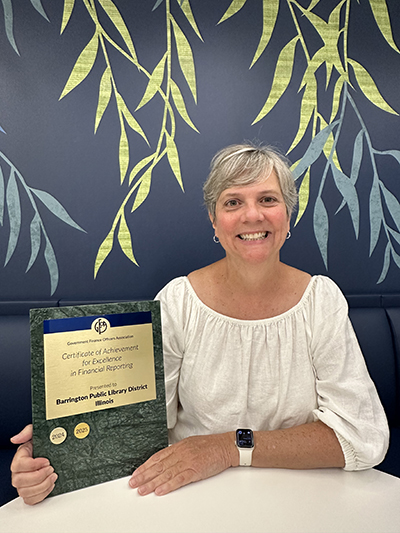 Photograph of Finance Manager Lauren Rosenthal holding an award plaque