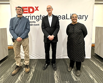 Two men and one woman stand in front of a banner reading TEDxBarringtonAreaLibrary