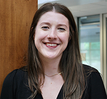 Image of woman smiling as she stands in the Library atrium